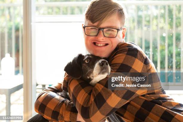 portrait of teenager with down syndrome and dog - perro adiestrado fotografías e imágenes de stock
