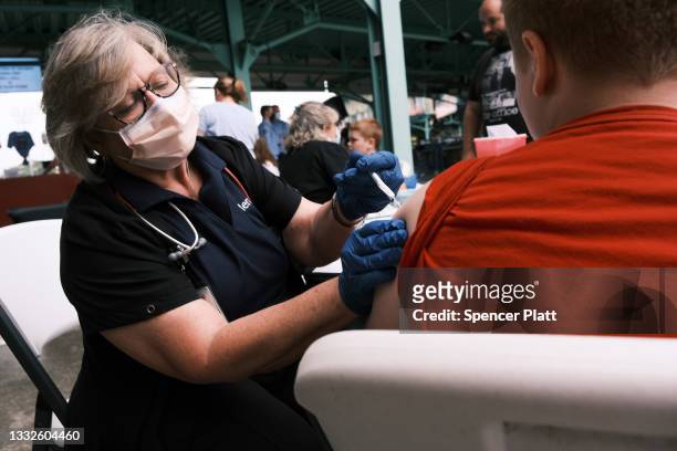 Nurse administers the Covid-19 vaccine to a teen at a baseball game on August 05, 2021 in Springfield, Missouri. According to the latest numbers from...