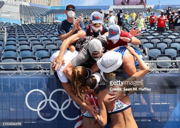 April Ross and Alix Klineman of Team United States receive hugs after defeating Team Australia during the Women's Gold Medal Match on day fourteen of...