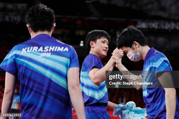 Harimoto Tomokazu of Team Japan shakes hands with his teammate Mizutani Jun during his Men's Team Bronze Medal table tennis match on day fourteen of...