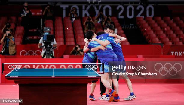 Team Japan players embrace after winning their Men's Team Bronze Medal table tennis match on day fourteen of the Tokyo 2020 Olympic Games at Tokyo...