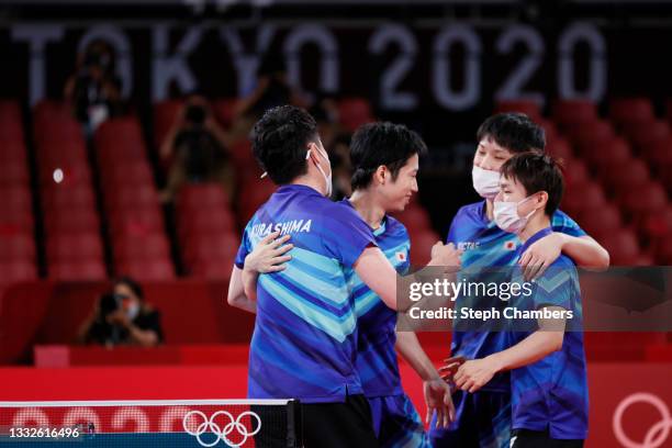 Mizutani Jun of Team Japan is embraced by his teammates Harimoto Tomokazu and Koki Niwa after winning their Men's Team Bronze Medal table tennis...