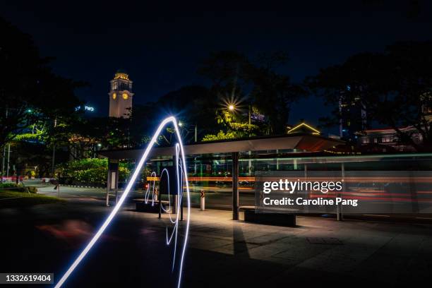 rushing to catch the bus captured in twirling light trail. - night 100 stock pictures, royalty-free photos & images