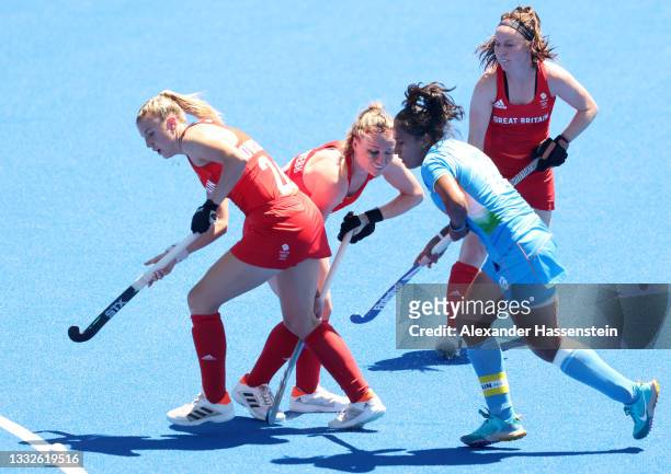 Hollie Pearne-Webb and Lily Owsley of Team Great Britain move the ball past Rani of Team India during the Women's Bronze medal match between Great...