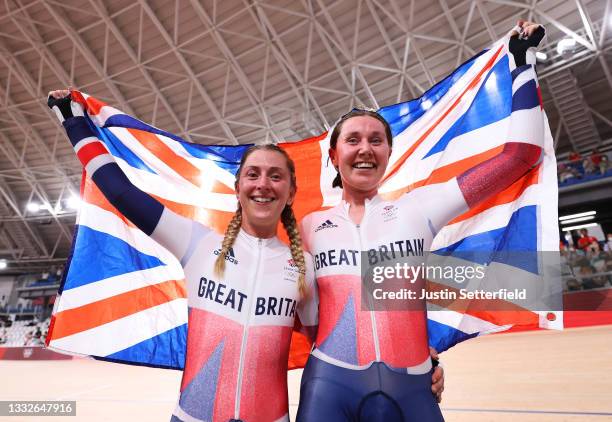 Laura Kenny and Katie Archibald of Team Great Britain celebrate winning a gold medal while holding the flag of they country during the Women's...