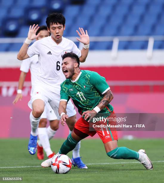 Alexis Vega of Team Mexico is tackled by Wataru Endo of Team Japan leading to a penalty for Mexico during the Men's Bronze Medal Match between Mexico...