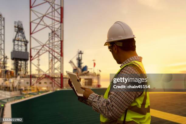 drilling engineer use tablet for working inspection control in oil drilling rig. oil and gas industry concept. - plattform stock-fotos und bilder