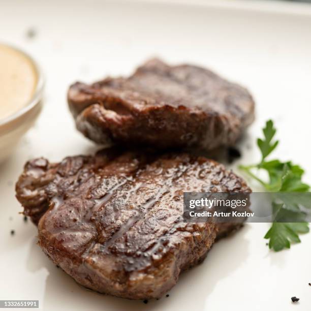grilled tenderloin, juicy steak or meat fillet with herbs and mustard on white plate. close-up shot. soft focus - bison meat stock pictures, royalty-free photos & images