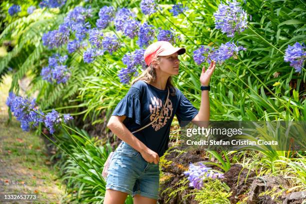 girl smelling flowers in funchal, madeira - funchal stock-fotos und bilder