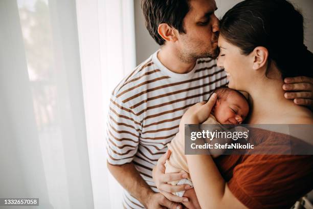 mother and father taking care of newborn son - open enrollment begins for third year of affordable care act stockfoto's en -beelden