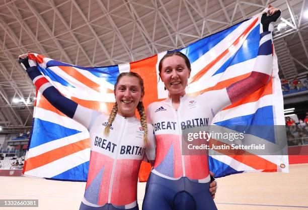 Laura Kenny and Katie Archibald of Team Great Britain celebrate winning a gold medal while holding the flag of they country during the Women's...