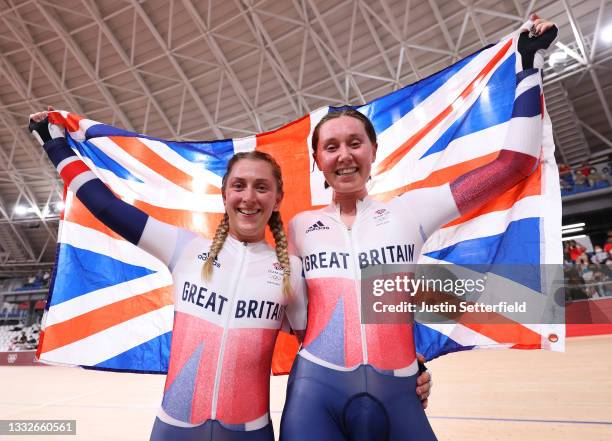 Laura Kenny and Katie Archibald of Team Great Britain celebrate winning a gold medal while holding the flag of they country during the Women's...