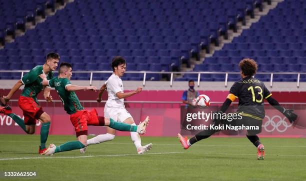 Kaoru Mitoma of Team Japan scores their side's first goal past Guillermo Ochoa of Team Mexico during the Men's Bronze Medal Match between Mexico and...