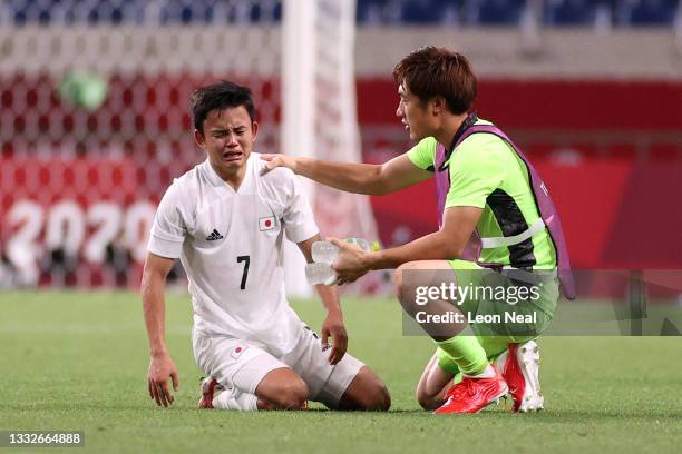 Takefusa Kubo of Team Japan looks dejected as he is consoled by Keisuke Osako of Team Japan following defeat in the Men's Bronze Medal Match between...