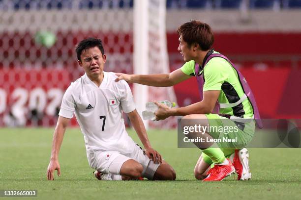 Takefusa Kubo of Team Japan looks dejected as he is consoled by Keisuke Osako of Team Japan following defeat in the Men's Bronze Medal Match between...