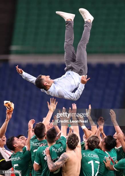 Jaime Lozano, Head Coach of Mexico is thrown in the air by his players following victory in the Men's Bronze Medal Match between Mexico and Japan on...