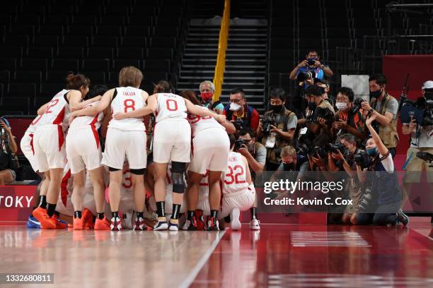 Team Japan celebrates in front of photographers following their victory over France in a Women's Basketball Semifinals game on day fourteen of the...