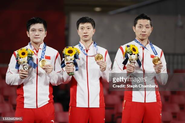 Team China players Fan Zhengdong, Ma Long , and Xu Xin pose for their medals during the medal ceremony of the Men's Team Gold Medal table tennis on...