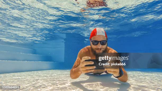 binge watching with mobile phone underwater: tv series addiction - binge tv stockfoto's en -beelden