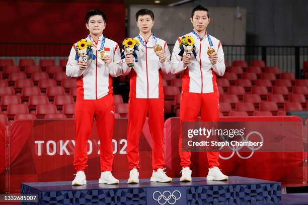 Team China players Fan Zhengdong, Ma Long , and Xu Xin pose with their medals during the medal ceremony of the Men's Team Gold Medal table tennis on...