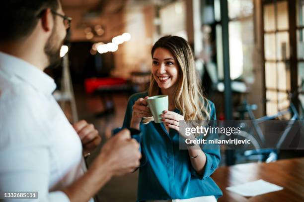 colleagues drinking coffee in the office - office flirt stock pictures, royalty-free photos & images