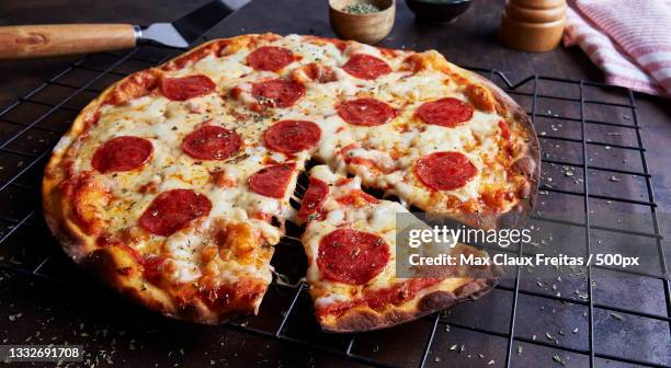 high angle view of pizza on table - pepperoni pizza stockfoto's en -beelden