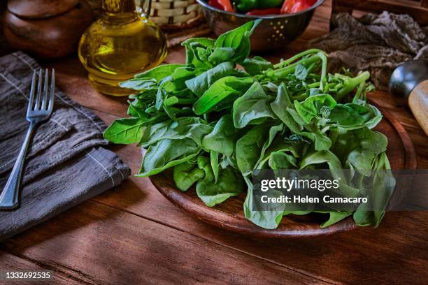 fresh leaves of spinach on rustic wooden table. - spenat bildbanksfoton och bilder