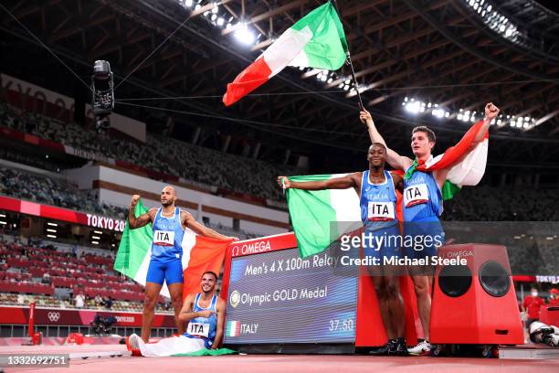 Lorenzo Patta, Lamont Marcell Jacobs, Eseosa Fostine Desalu and Filippo Tortu of Team Italy celebrate winning the gold medal in the Men's 4 x 100m...