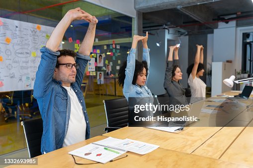 Workers doing stretching exercises in a business meeting at the office Workers doing stretching exercises in a business meeting at the office