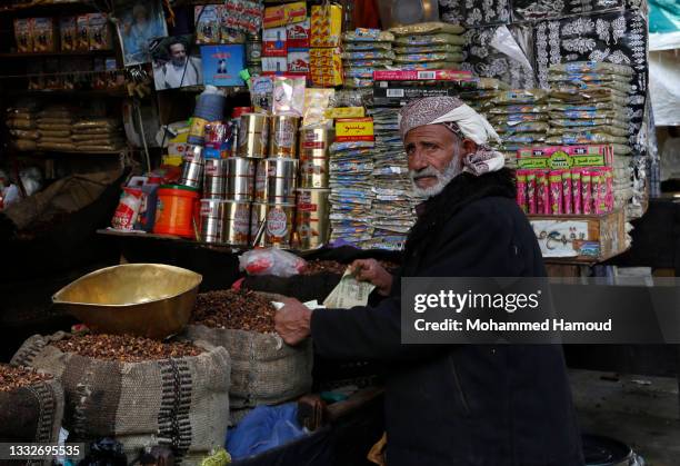 Yemeni man buys food from a vendor while doing shopping at a market amid soaring commodities prices, among them, are food, on August 06, 2021 in...