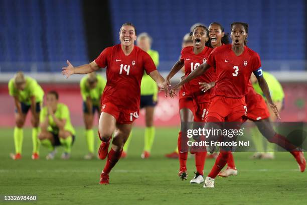 Vanessa Gilles, Ashley Lawrence and Kadeisha Buchanan of Team Canada celebrate following their team's victory in the penalty shoot out in the Women's...