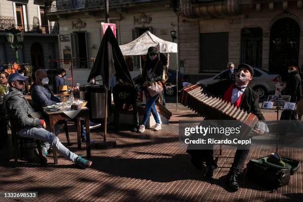 Musician plays bandoneon in a square of San Telmo on July 31, 2021 in Buenos Aires, Argentina. Due the progress in the vaccination campaign against...