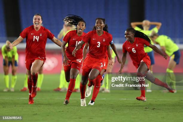 Vanessa Gilles, Ashley Lawrence and Kadeisha Buchanan of Team Canada celebrate following their team's victory in the penalty shoot out in the Women's...