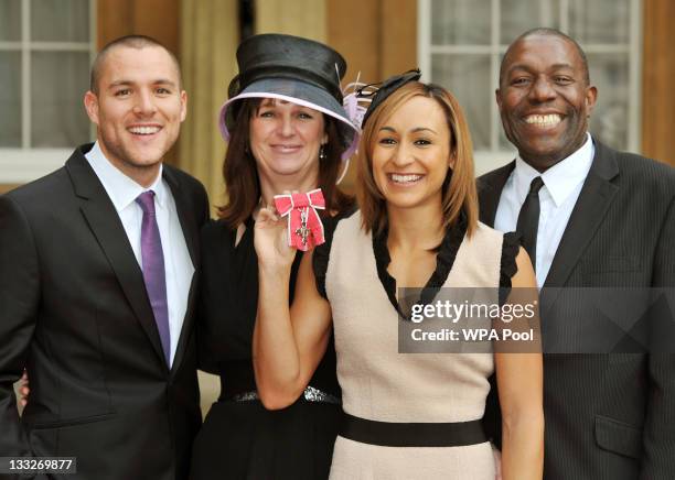 British athlete Jessica Ennis holds her MBE alongside her Fiancee Andy Hill and parents Alison and Vinny after it was presented to her by Prince...