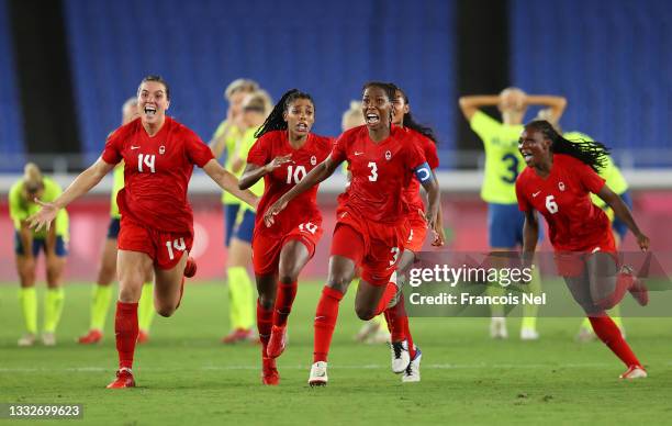 Vanessa Gilles, Ashley Lawrence and Kadeisha Buchanan of Team Canada celebrate following their team's victory in the penalty shoot out in the Women's...