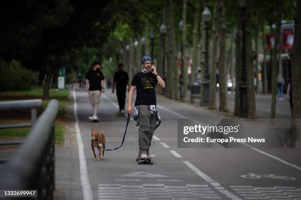 Man walks his dog while skateboarding down Diagonal Avenue on August 6 in Barcelona, Catalonia, Spain. Barcelona faces a tourist season this summer...