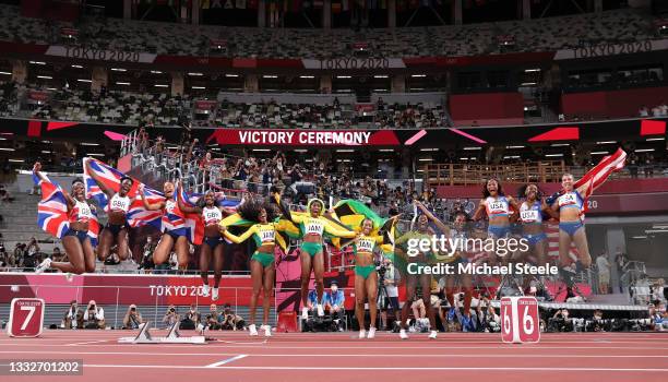 The relay runners representing Team Great Britain, Team Jamaica and Team United States celebrate winning their respective medals after the Women's 4...