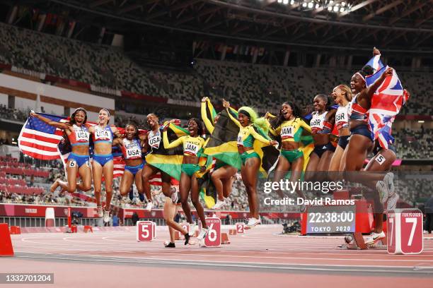 The relay runners representing Team Great Britain, Team Jamaica and Team United States celebrate winning their respective medals after the Women's 4...