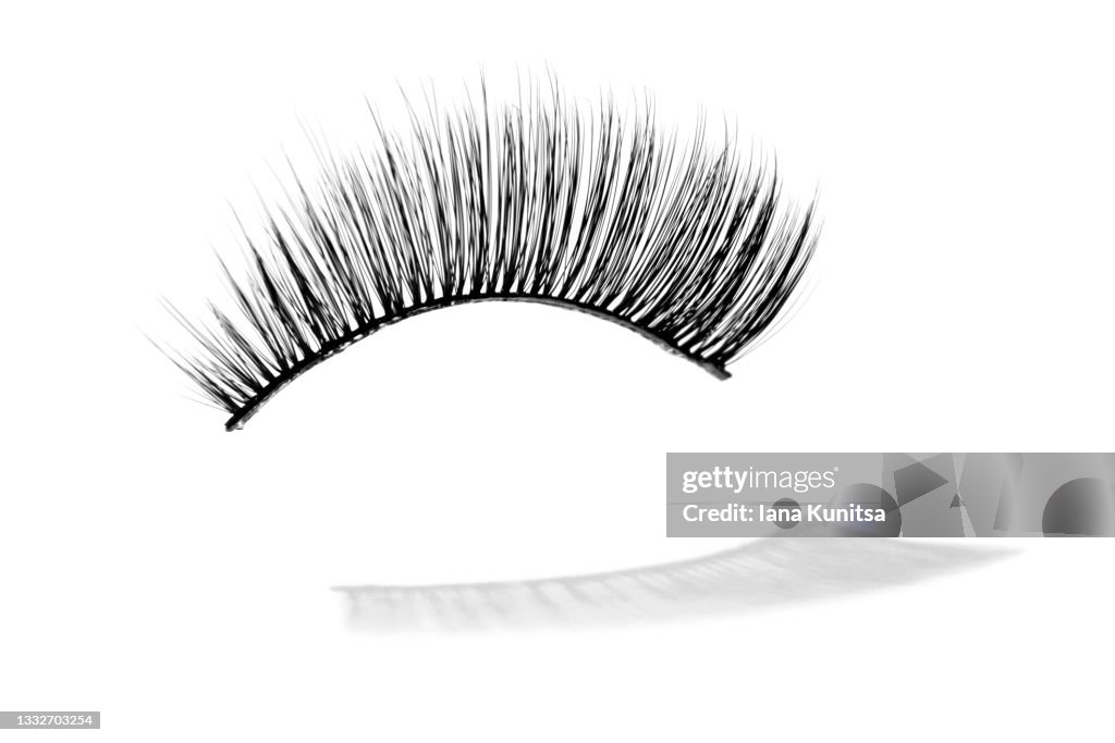 False eyelash and their shadow on white background, isolated. Mascara. Beauty pattern. Makeup accessories concept. Cosmetics products. Eyelash extension tools. Closeup.