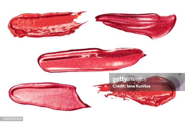 set of red lipstick smears on white background. isolated for design. lip gloss samples are smudged. beauty cosmetic. makeup and skin care products. closeup. - glossy lipstick fotografías e imágenes de stock