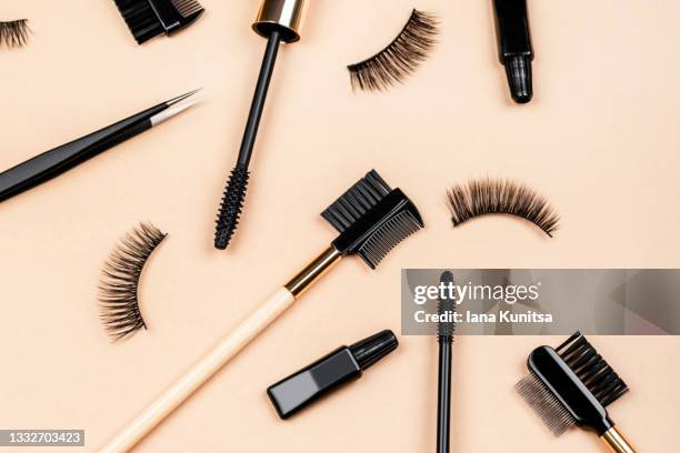 various tools for eye lash extensions on trendy pastel beige background. makeup accessories. cosmetics. fake eyelashes, glue, brush and tweezers. - eye make up stock pictures, royalty-free photos & images