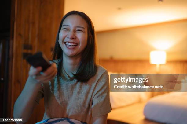 happy woman enjoying watching television at night. - binge watching stock pictures, royalty-free photos & images