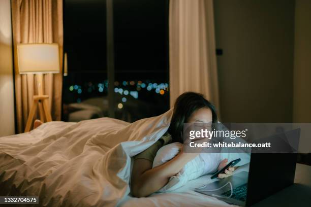 mulher sonolenta assistindo filme tarde da noite na cama. - late night television - fotografias e filmes do acervo