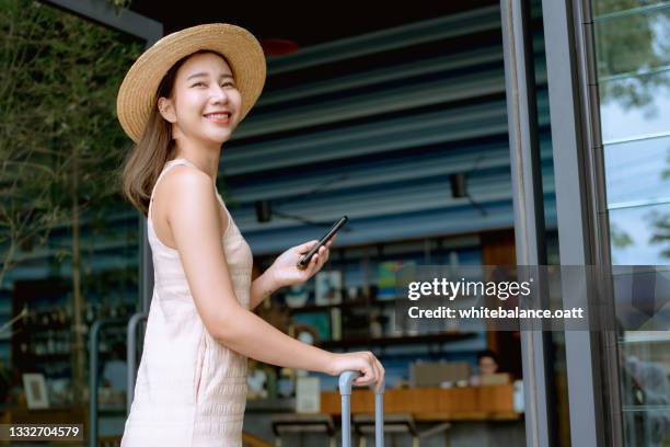 tourist pulling her luggage into modern hotel. - thailand hotel stock pictures, royalty-free photos & images