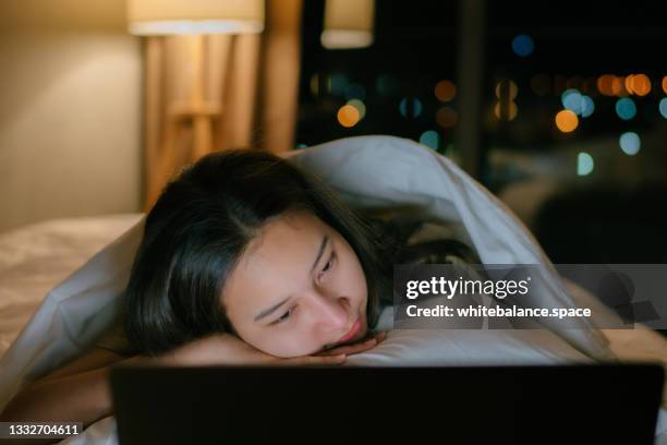 sleepy woman watching movie late night on bed. - film credits bildbanksfoton och bilder