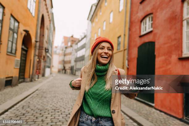 young smiling woman on a city break - luggage stockfoto's en -beelden