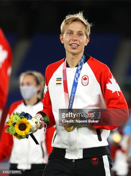 Gold medalist Quinn of Team Canada looks on with their gold medal during the Women's Football Competition Medal Ceremony on day fourteen of the Tokyo...