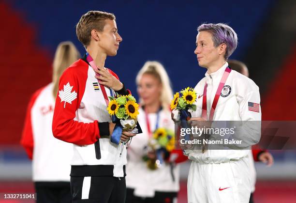 Gold medalist Quinn of Team Canada interacts with Bronze medalist Megan Rapinoe of Team United States during the Women's Football Competition Medal...