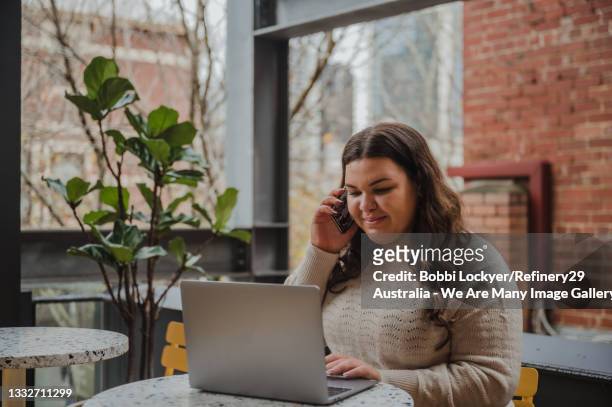 young woman multi-tasking at work - aboriginal stockfoto's en -beelden