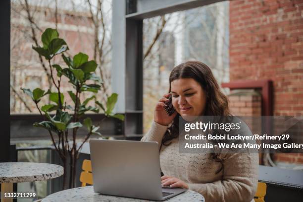 young woman multi-tasking at work - businesswoman phone stock pictures, royalty-free photos & images